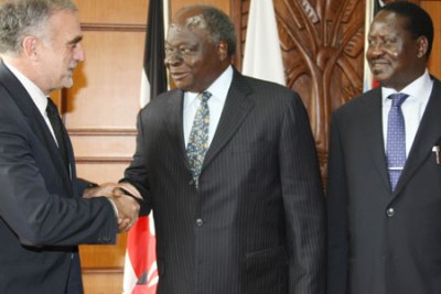 President Mwai Kibaki welcomes the International Criminal Court's chief prosecutor, Luis Moreno Ocampo, in Nairobi as Prime Minister Raila Odinga looks on.