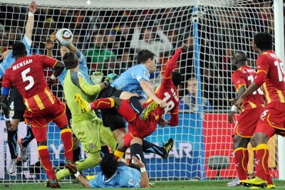 Luis Suarez of Uruguay handballs a shot on goal by Dominic Adiyiah. He was sent off, but his illegal action gave Uruguay another chance, which they exploited to win the match.
