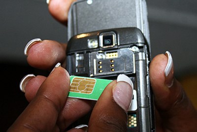 A mobile phone user inserts a SIM card into a phone.