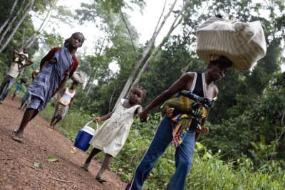 Refugees from Côte d'Ivoire walk along a forest trail to find safety and shelter in eastern Liberia.