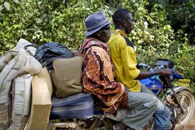 An Ivorian refugee gets a lift on a motorbike taxi to the southeastern Liberian town of Zwedru (file photo).