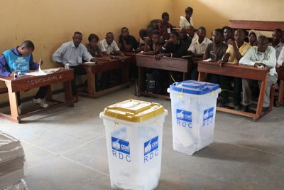 Des témoins des candidats devant les urnes le 28/11/2011 dans un bureau de vote au quartier Makelele dans la commune de Bandalungwa à Kinshasa, pour les élections de 2011 en RDC.