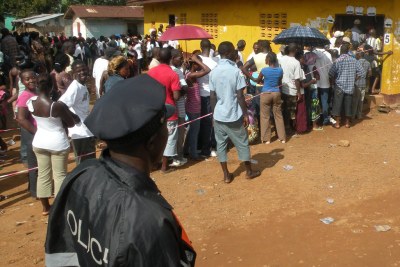 A police officer monitors a voting queue.