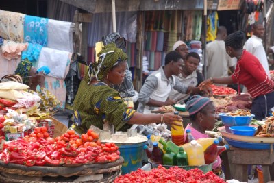 A market in Nigeria showing traders selling red pepper, oil palm, 