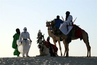 A group of Tuareg men in traditional dress silhouetted on the crest of a sand dune at an oasis, west of Timbuktu, Mali (file photo).