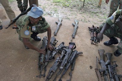 Un Casque bleu de l'ONU avec des armes collectées auprès de milices en Côte d'Ivoire.