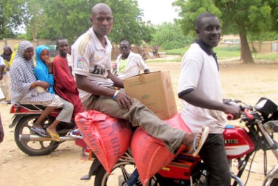 Commune de Diffa : un bénéficiaire prend un taxi moto pour transporter l'aide qu'il a reçue.