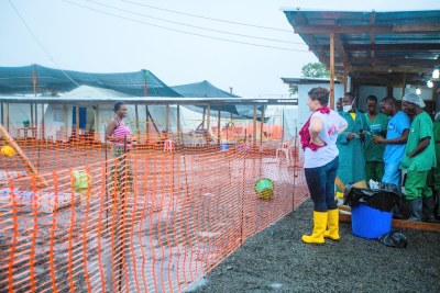 An MSF volunteer speaks from a safe distance with an Ebola patient.