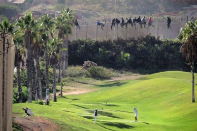 Sur un terrain de golf à Melilla, on continue de jouer alors que des personnes escaladent la triple clôture d'enceinte, des grillages hérissés de barbelés, pour tenter d'entrer dans cette enclave espagnole en Afrique du Nord.