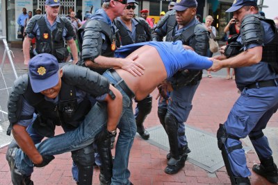 Police officers arrest a Democratic Alliance supporter near Parliament in Cape Town before President Jacob Zuma's state of the nation address on February 13, 2015.