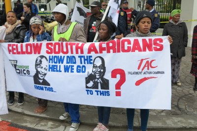 Anti-corruption demonstrators protest in front of Parliament with a sign comparing former leader Nelson Mandela with President Jacob Zuma (file photo).