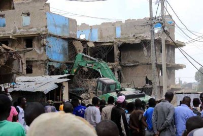 Residents watch as an earth mover brings down a building in Mathare Area 1 on May 17, 2016.