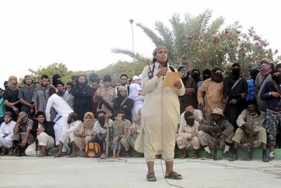 Un responsable de l’État islamique lit une proclamation peu avant l'exécution publique de deux hommes accusé de « sorcellerie » à Syrte, en Libye.