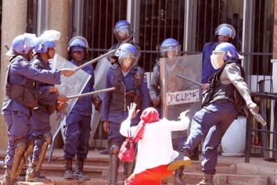 Une femme battue par des policiers à Harare.