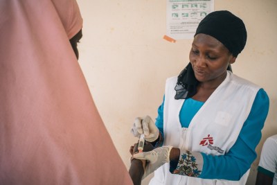 Member of MSF Nigeria Emergency Response Unit (NERU) attends a woman in the meningitis treatment center run by MSF in Sokoto Mutalah Mohamad Hospital.