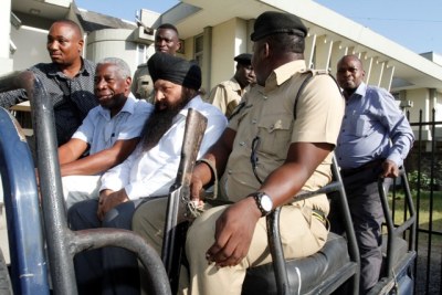 Businessmen James Rugemalira and Harbinder Singh Sethi (second and third left, respectively) in a police vehicle at Kisutu Resident Magistrate's court compound in Dar es Salaam.