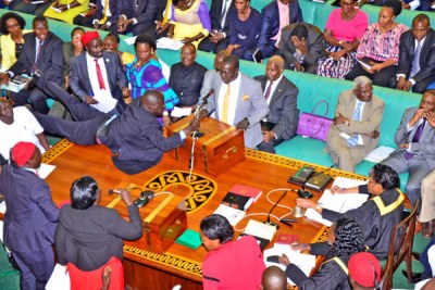 Aruu County MP Samuel Odonga Otto jumps on to the table to grab the microphone from Bukholi Central MP Solomon Silwany during the age limit debate in Parliament on Tuesday.