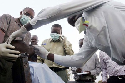 Health officials examines a patient after a Swine flu scare in Kisumu (file photo).