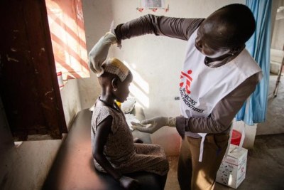 Un membre du personnel MSF examine une jeune fille blessée à la tête dans l'hôpital d'Ulang, dans le nord-est du Soudan du Sud. 2019.