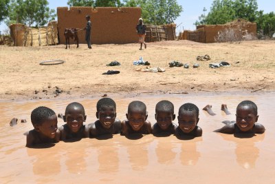 Des garçons prennent un bain dans une marre à Zinder, dans le centre du Niger.