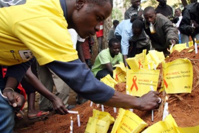 Members of the public light candles at a symbolic grave marked in Eldoret on World Aids Day (file photo).