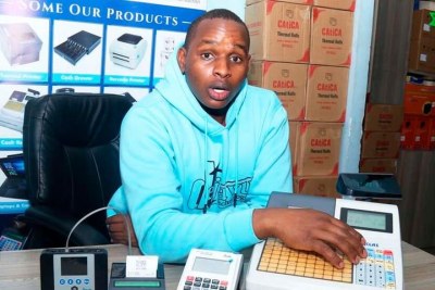 Dejavu Technologies Ltd ICT Technician Tony Mutune explains how a new model of Electronic Tax Register (ETR) machine works during the interview at his office in Nairobi.