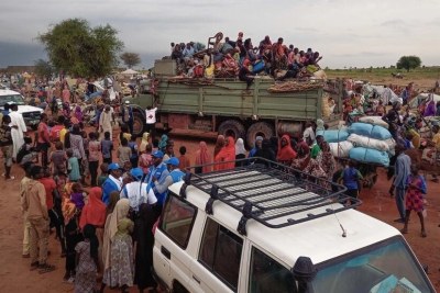 À la frontière soudanaise, les réfugiés prennent d'assaut les camions du HCR qui les transporteront vers la ville d'Adré, loin des horreurs de la guerre.