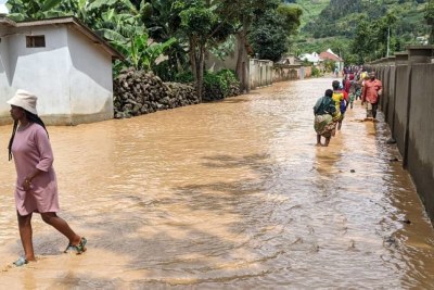 Residents wade through a flooded residential area in Rwanda (file photo).